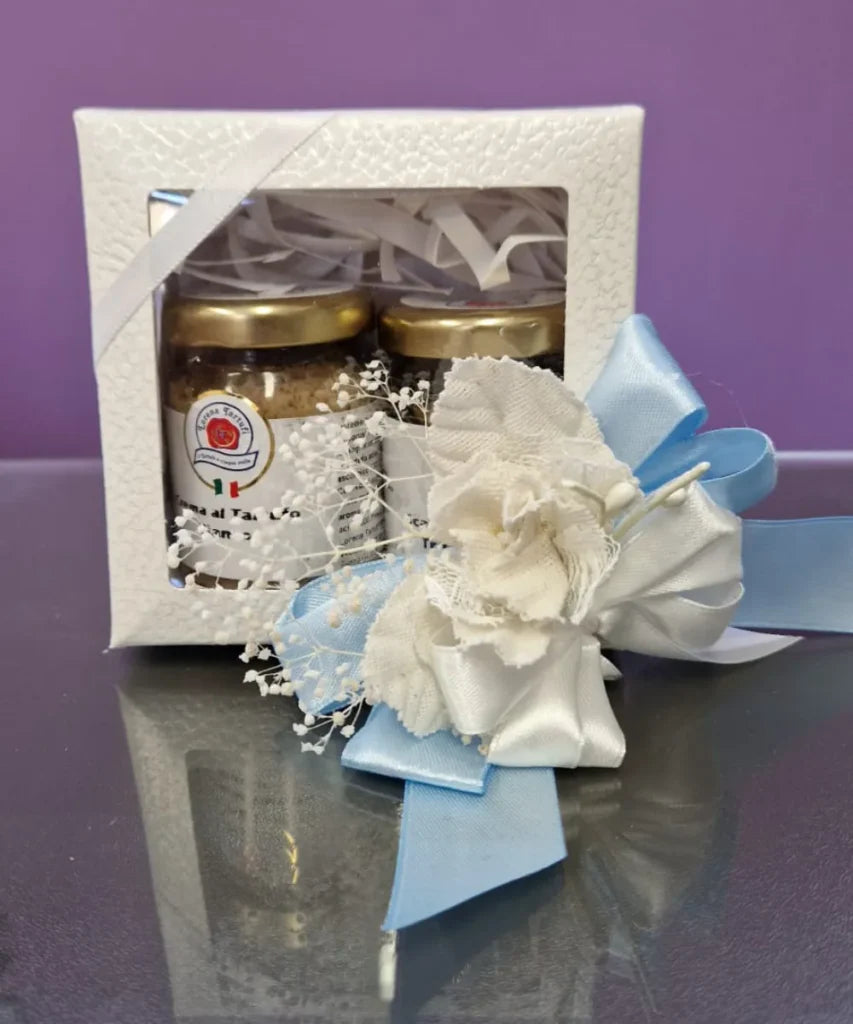 Bomboniere artigianali con barattoli, fiori bianchi e fiocco azzurro